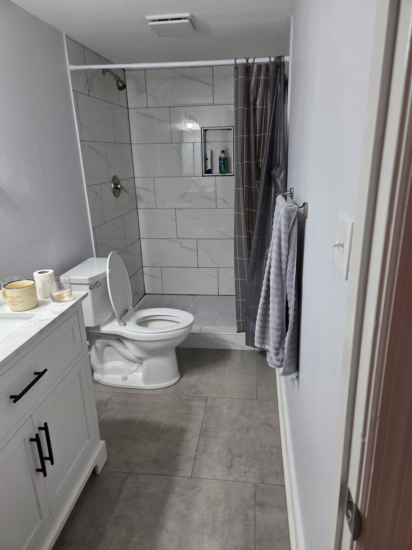 Finished bathroom with tile shower, vanity and modern fixtures