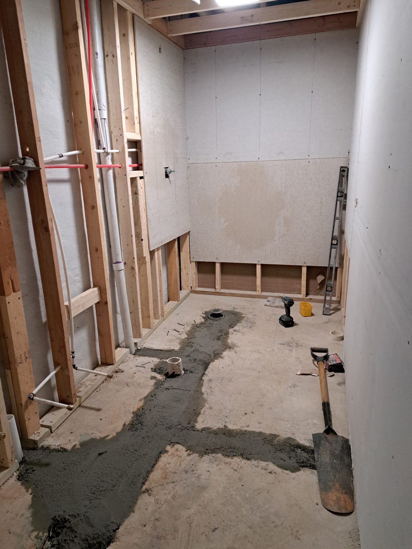 Bathroom rough-in with concrete floor and plumbing before remodel