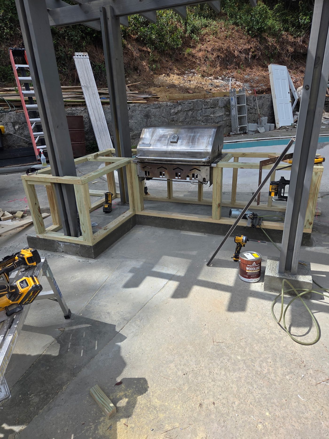 Outdoor kitchen framing under construction with tools on site