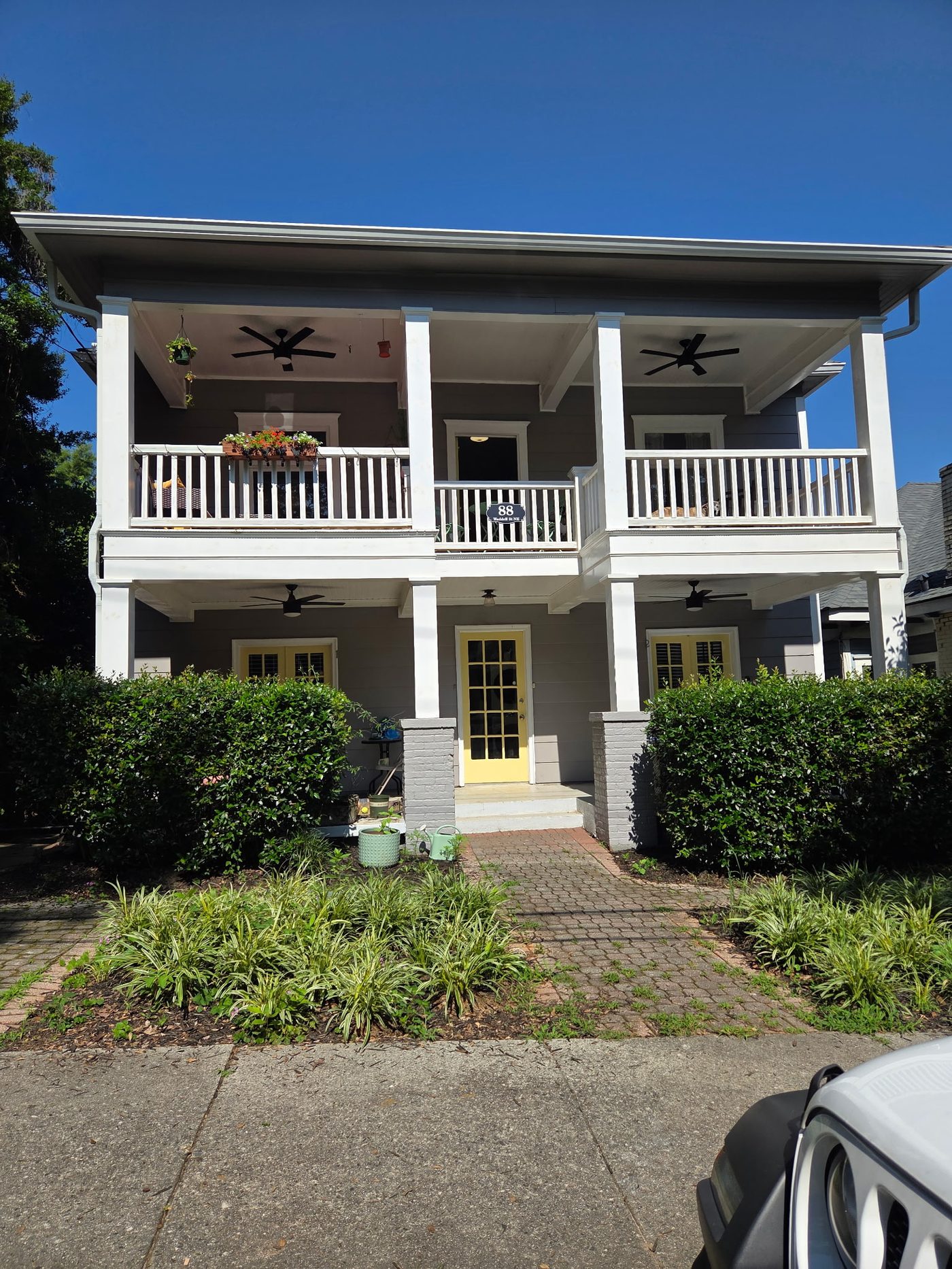 Finished two-story porch with ceiling fans and yellow front door